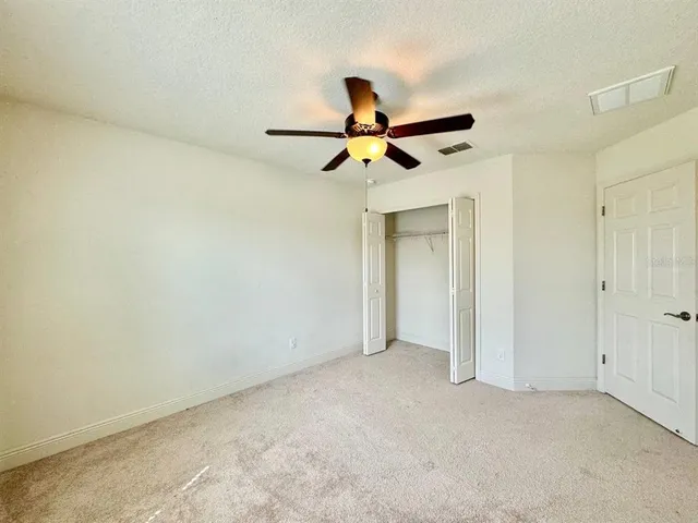 a view of a big room with a ceiling fan and a window