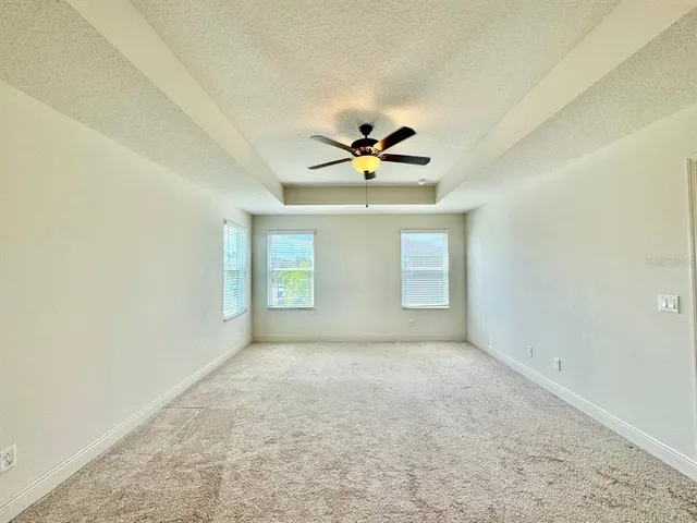 an empty room with a window and a ceiling fan