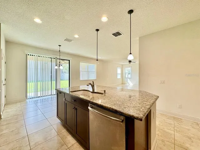 a kitchen with stainless steel appliances granite countertop a sink stove and cabinets