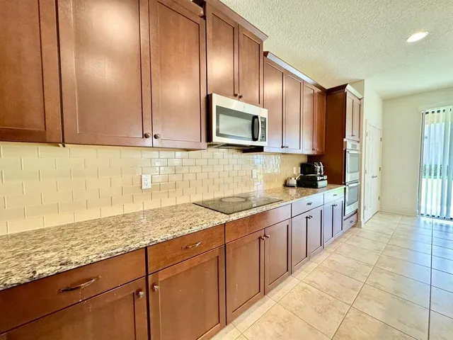 a kitchen with stainless steel appliances granite countertop a refrigerator and a sink