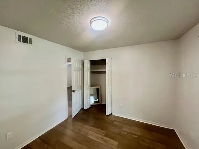 a view of a room with wooden floor and closet