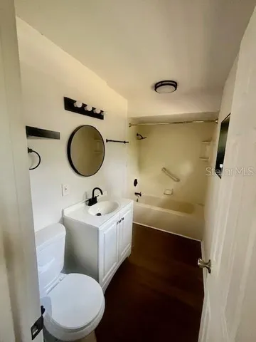 a bathroom with a sink mirror vanity and toilet