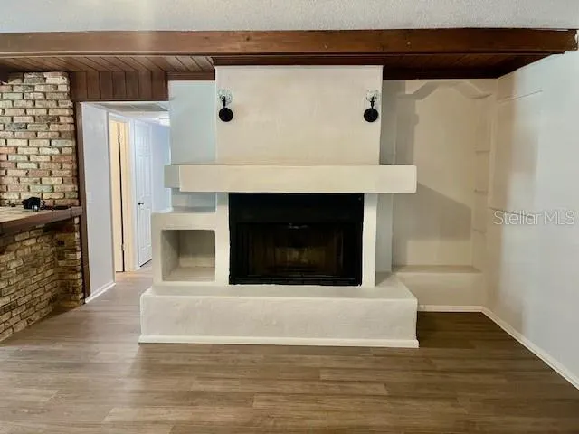 a living room with fireplace and a wooden floor