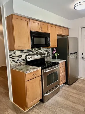 a kitchen with stainless steel appliances a stove microwave and refrigerator