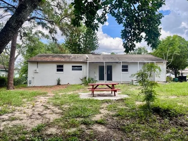 a view of a house with backyard sitting area and garden