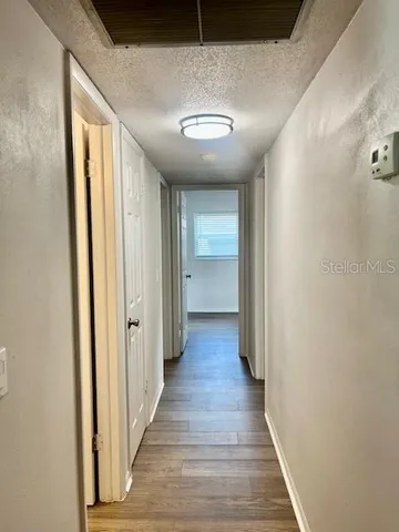 a view of a hallway with wooden floor