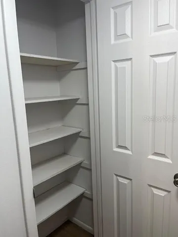 a view of walk in closet with empty racks