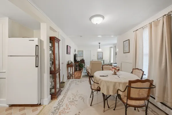 a view of a dining room with furniture and a refrigerator