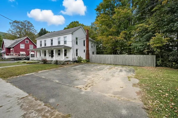 a view of a white house with a yard