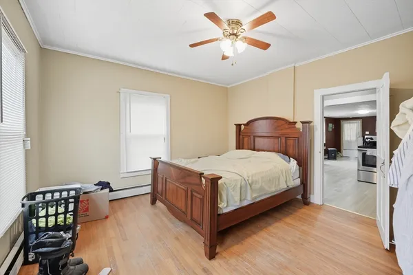 a bedroom with a bed chandelier and a window