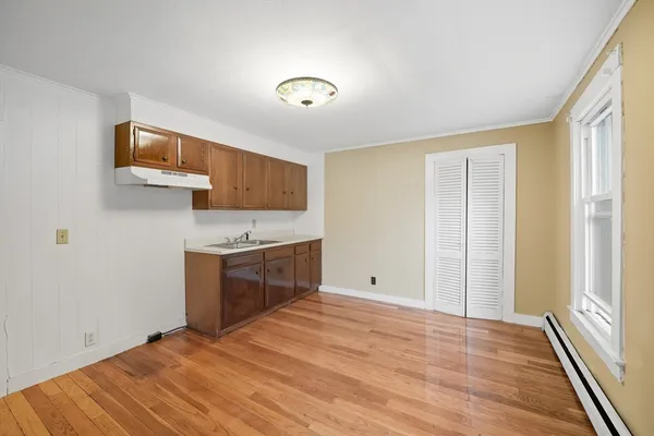 a kitchen with a sink cabinets and wooden floor