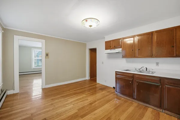 a kitchen with granite countertop a sink cabinets and wooden floor