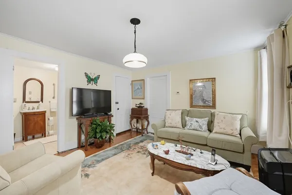 a living room with furniture a flat screen tv and a window