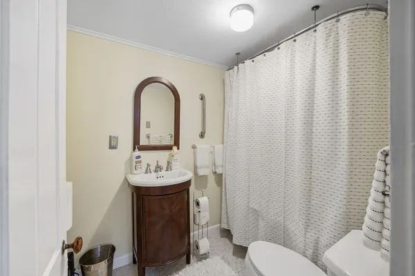 a bathroom with a sink toilet and a mirror