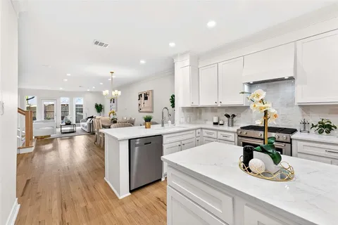 a kitchen with a sink white cabinets and counter space