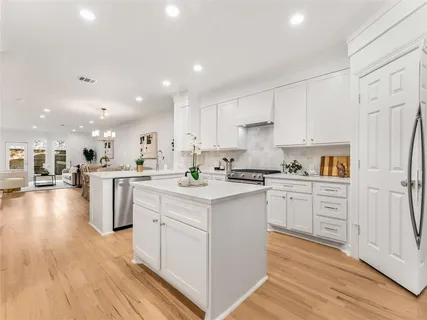 a kitchen with white cabinets appliances and center island