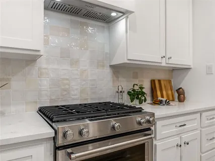 a stove top oven sitting inside of a kitchen