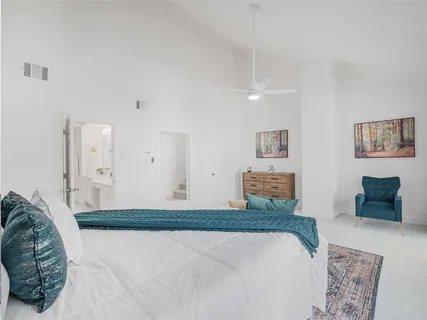 a bedroom with a bed and painting on the wall