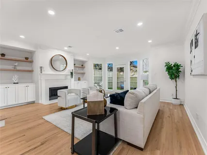 a living room with fireplace furniture and a large window