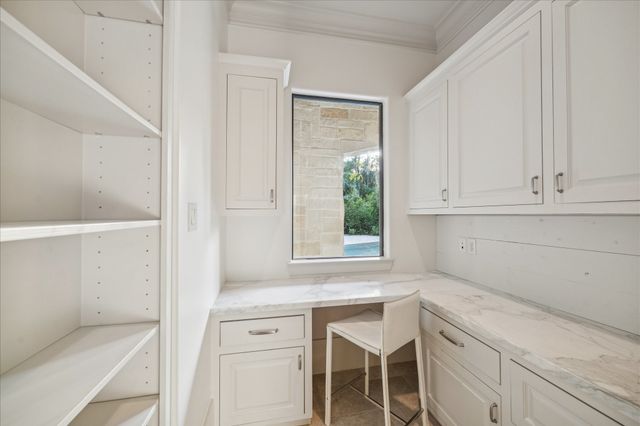 a kitchen with white cabinets and a window