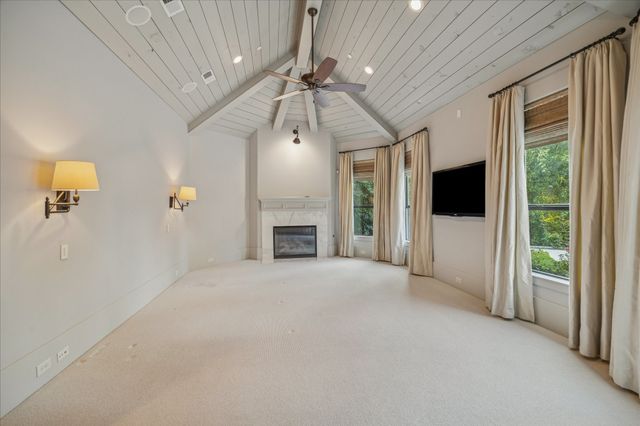 a view of an empty room with a fireplace and a window