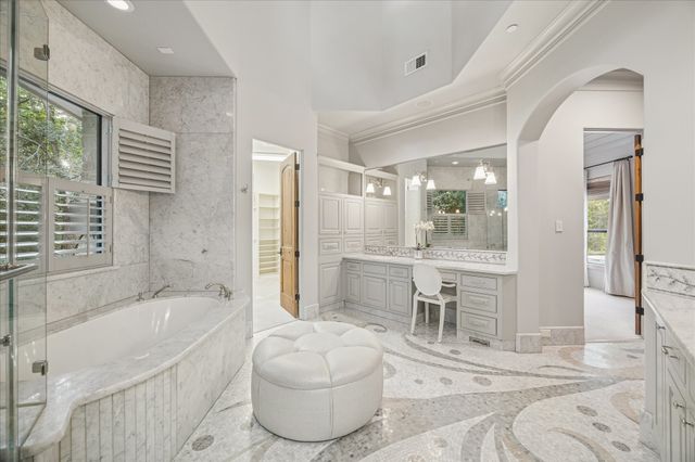 a spacious bathroom with a tub sink and mirror