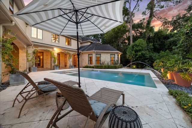 a view of a swimming pool with two chairs in a patio