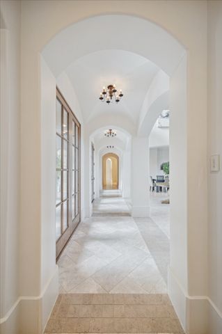 a view of a hallway with a window and a chandelier