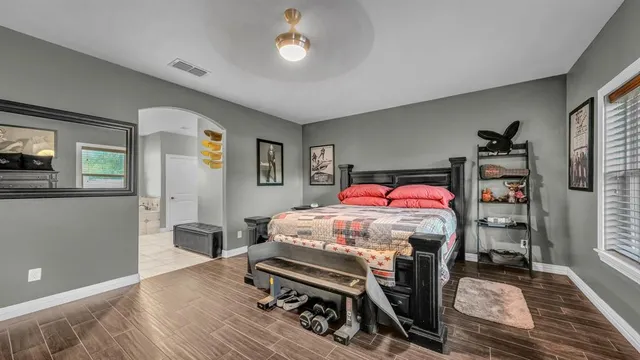 a bedroom with a bed and wooden floor
