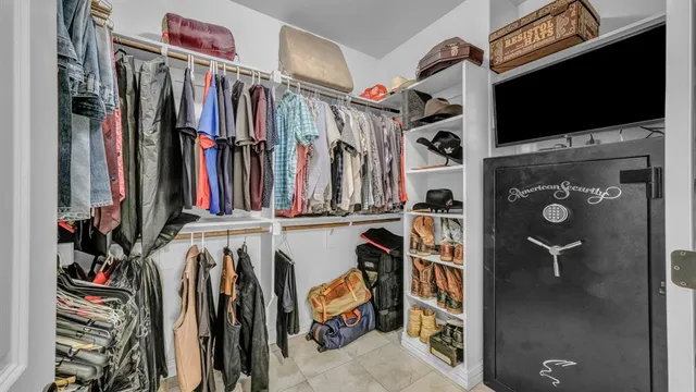 a view of walk in closet with clothes and shoes