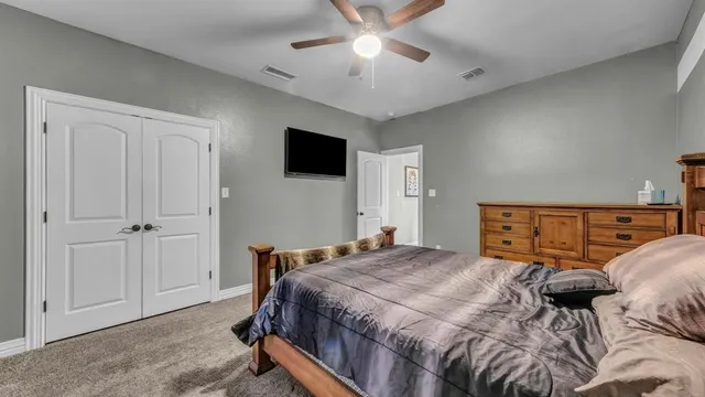 a bedroom with a large bed and a tv