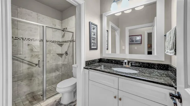 a bathroom with a granite countertop sink toilet and shower
