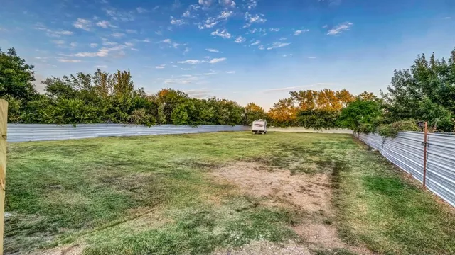 a view of a field with an trees in the background