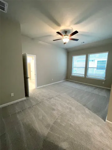 an empty room with windows and fan