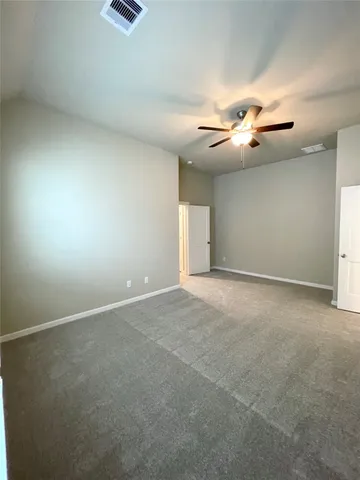 en empty room with windows and a ceiling fan