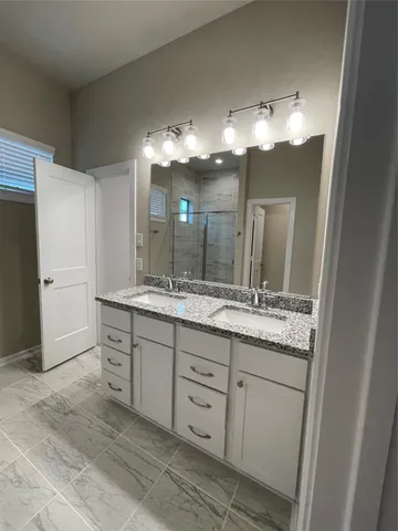a bathroom with a double vanity sink and a mirror