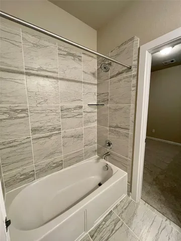 a bathroom with a bathtub and shower
