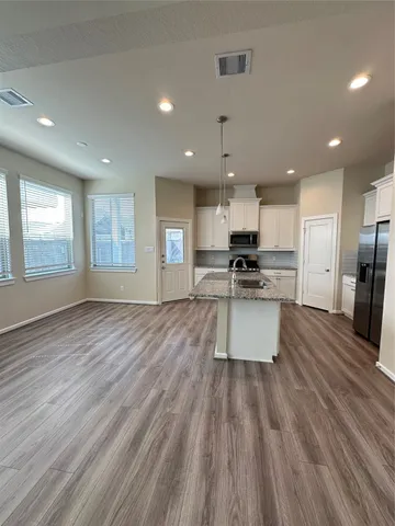 an open kitchen with kitchen island and stainless steel appliances