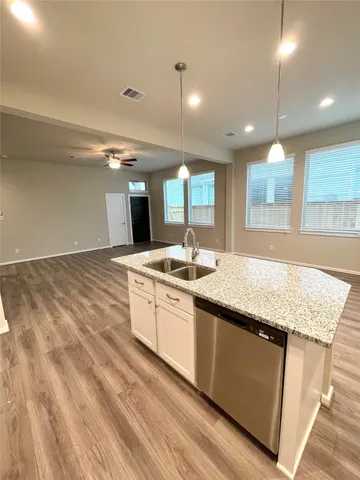 a large kitchen with stainless steel appliances granite countertop a sink a stove and a wooden floors