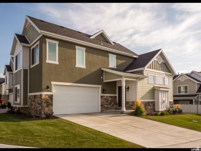 9294 South Rose Cottage Way, Unit 207 Sandy, UT 84094 - Photo 9 of 10 Craftsman inspired home with stone siding, an attached garage, board and batten siding, concrete driveway, and roof with shingles