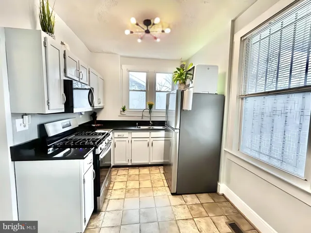 a kitchen with a refrigerator a sink and cabinets