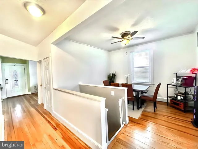 a view of a livingroom with furniture a ceiling fan and wooden floor