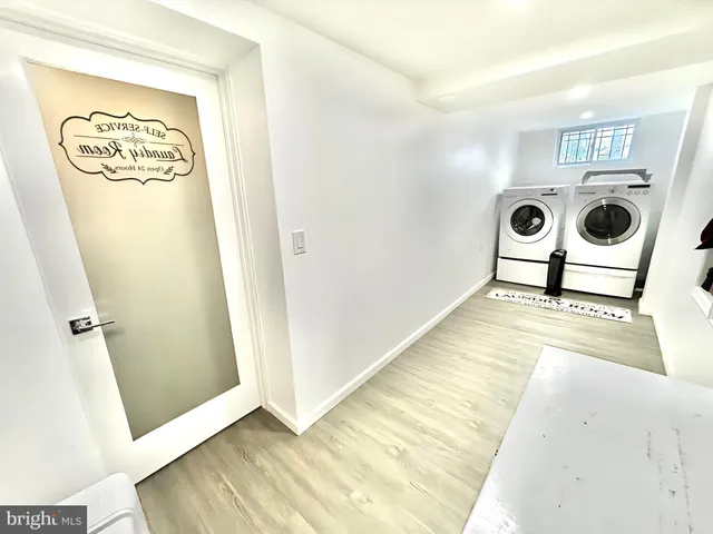 a view of a hallway with wooden floor and a bathroom