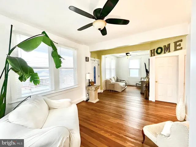 a living room with couches a fireplace and a large window with garden view