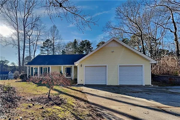 a view of a white house with a yard and large tree