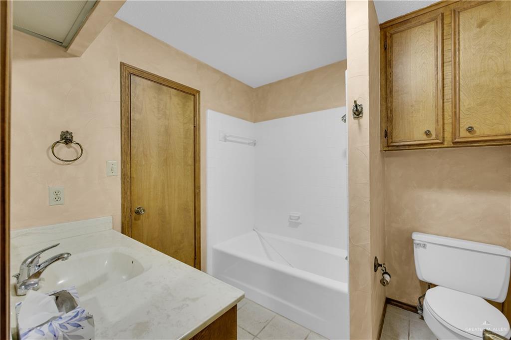 2016 South 5th Street, Unit 17 McAllen, TX 78503 - Photo 9 of 20 a bathroom with a granite countertop sink toilet and shower