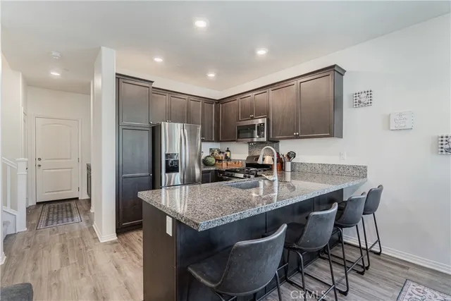 a kitchen with kitchen island a refrigerator stove microwave and cabinets