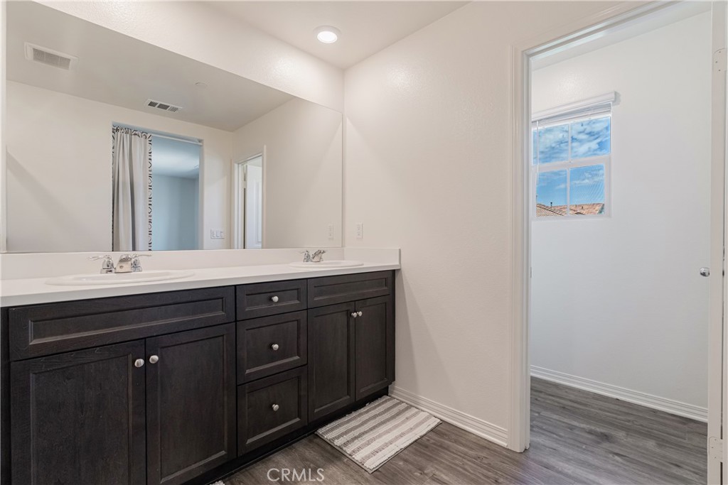 41973 Rondo Street, Unit 1203 Murrieta, CA 92562 - Photo 19 of 48 a bathroom with a double vanity sink and mirror
