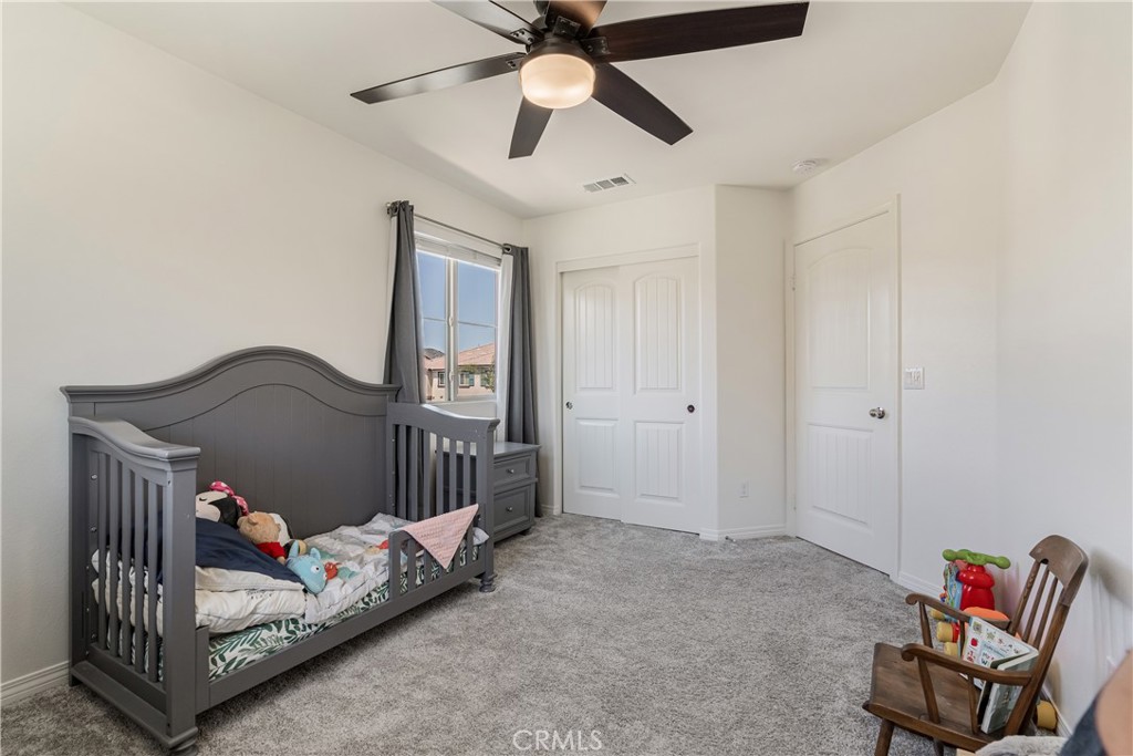 41973 Rondo Street, Unit 1203 Murrieta, CA 92562 - Photo 23 of 48 a bedroom with a bed and a chandelier