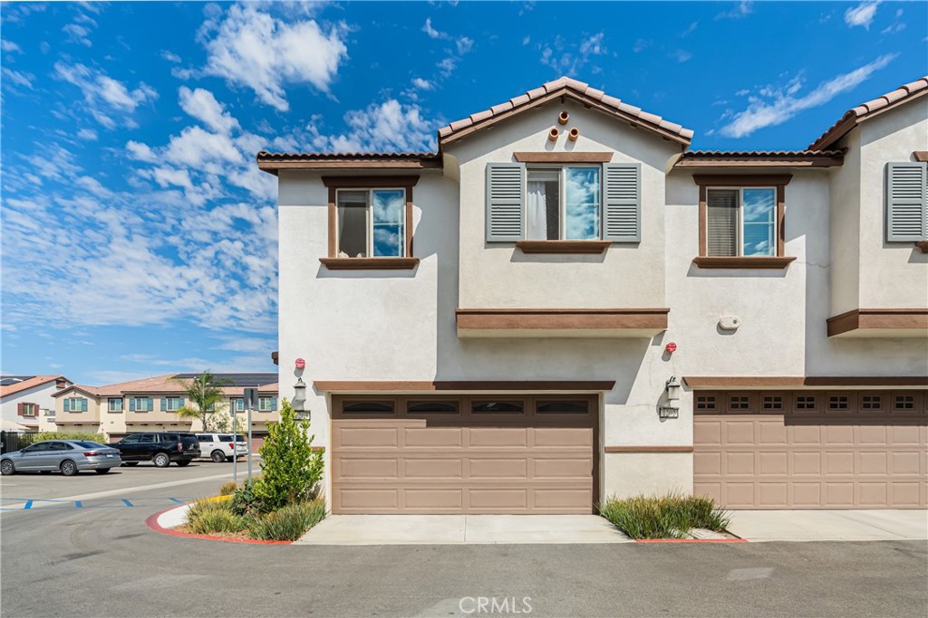 41973 Rondo Street, Unit 1203 Murrieta, CA 92562 - Photo 34 of 48 a front view of a house with a yard and garage